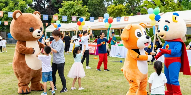 Children and adults enjoying vibrant mascot costumes at a community event.