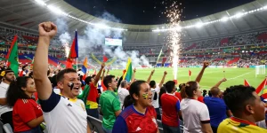 Penggemar tebak skor Piala Dunia 2026 dengan semangat di stadion yang meriah.
